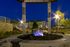 Charming outdoor fire pit area with stone seating, set against a beautiful apartment backdrop under a starlit sky.