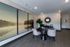 Elegant office space with modern decor, featuring large serene landscape artwork, chic seating area, and stylish reflective mirror.