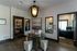Elegant apartment lobby featuring a modern chandelier, stylish glass table, and cozy armchairs, creating a welcoming atmosphere.