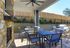 Charming outdoor patio with sleek dining set, modern grill, and rustic stone fireplace, perfect for entertaining.