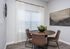 Chic dining area featuring a round wooden table with sleek leather chairs, accentuated by elegant decor and abundant natural light.
