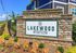 Inviting entrance to Lakewood Station, showcasing beautiful landscaping and a stylish stone sign under a clear blue sky.