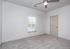 Bright, cozy room with a modern ceiling fan, plush carpet, and ample natural light through a window with blinds.