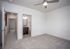 Bright and spacious bedroom featuring plush carpet, modern ceiling fan, and en-suite bathroom with sleek cabinetry.