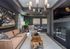 Elegant living room with modern chandelier, cozy fireplace, stylish art pieces, rustic coffee table, and plush sofa.