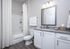 Elegant bathroom with stylish granite countertop, modern fixtures, and a pristine white shower curtain, offering a serene and sophisticated ambiance.