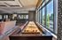 Bright and modern apartment lounge featuring a shuffleboard table, cozy seating, and large windows with scenic views.