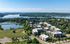 Aerial view of a modern apartment complex surrounded by lush greenery and serene lakes, offering picturesque views and tranquil living.