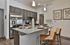 Modern kitchen design featuring granite countertops, sleek stainless steel appliances, and elegant cabinetry, complete with stylish bar seating and contemporary pendant lighting.