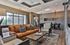 Elegant living room with large windows, modern lighting, and chic decor offering a cozy ambiance.