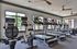 Contemporary fitness center with state-of-the-art treadmills, cycling machines, and large windows for natural light.