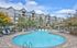 Luxurious apartment complex with a beautifully landscaped pool area, surrounded by elegant buildings and lush greenery, offering a relaxing retreat.