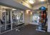 Spacious and modern fitness center featuring a variety of exercise equipment, bright mirrored walls, and ample natural light.