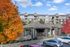 Charming apartment complex surrounded by vibrant autumn foliage, featuring modern architecture with balconies and ample parking.