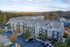 Beautiful apartment complex with modern architectural design, surrounded by lush trees and scenic views, showcasing ample parking and a friendly neighborhood vibe.