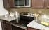 Modern kitchen with stainless steel appliances, chic granite countertops, and elegant dark wood cabinetry, ideal for culinary enthusiasts.