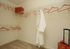 Spacious walk-in closet with elegant shelving, stylish hangers, and a chic robe, ideal for organized living.