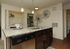 Elegant kitchen with granite countertops, dark wood cabinets, modern pendant lighting, and an integrated laundry area.