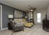 Inviting living room featuring a chic sofa with vibrant yellow accents, modern armchairs, a stylish ottoman, and elegant decor, enhancing cozy ambiance.