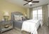 Chic bedroom with plush bedding, elegant gray and yellow decor, and soft lighting creating a cozy retreat.