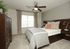 Modern bedroom with chic decor, featuring elegant furniture, a cozy bed with stylish pillows, and abundant natural light.