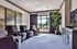 Modern living room with stylish armchairs, large landscape paintings, and a scenic window view.