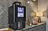Modern kitchenette boasting a sleek coffee machine, elegant tile backsplash, and contemporary decor, perfect for a cozy refreshment retreat.