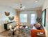 Bright and inviting living room featuring a modern orange sofa, stylish decor with natural textures, and expansive windows for ample light.
