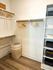 Elegant walk-in closet featuring wooden hangers, woven basket, and organized shelves for stylish living.