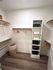 Elegant walk-in closet with sleek shelving, ample hanging space, and stylish storage solutions on hardwood flooring.