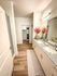 Elegant bathroom featuring a dual-sink vanity with granite countertops, stylish decor, and a spacious walk-in closet.