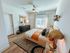 Chic bedroom with modern decor, featuring a large window, elegant dresser, and stylish bed with warm-toned accents.