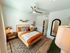 Inviting bedroom with modern decor, featuring a cozy bed, stylish side tables, and elegant lighting.