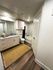 Sleek and modern bathroom featuring elegant wood flooring, a spacious vanity with stylish cabinetry, and a luxurious bathtub for relaxation.