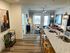 Modern open-plan apartment featuring a stylish granite kitchen island, cozy living area, and natural light from large windows.