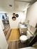 Chic bathroom with modern fixtures, textured wall art, and a cozy woven rug leading to a welcoming open living space.