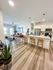 Modern open-plan living space featuring a stylish kitchen with granite countertops, cozy seating area, and sleek wood flooring.