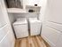 Modern laundry room featuring sleek white washer and dryer, complemented by elegant shelving and stylish decor.