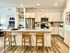 Modern open-concept kitchen with elegant granite countertops, sleek cabinets, and inviting breakfast bar seating in a stylish apartment.