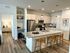 Modern kitchen with granite countertops, stainless steel appliances, and elegant bar seating, adjacent to a cozy, well-lit living space.