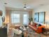 Chic living room with a contemporary leather sofa, stylish decor, and natural light-filled ambiance featuring modern art and plush seating.