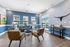 Inviting living room with blue accent walls, modern furniture, and abundant natural light overlooking a scenic view.