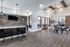 Modern open-concept lounge with chic bar seating, stylish brick accent wall, and vibrant dining area exuding elegance and comfort.