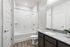 Chic modern bathroom featuring elegant granite countertops, sleek fixtures, and a bright tiled shower area for a luxurious touch.