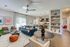 Contemporary open-plan living area featuring elegant decor, a cozy seating arrangement, modern kitchen, and stylish shelving, perfect for comfortable urban living.