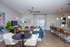 Modern open-concept living area with cozy seating, chic dining setup, and elegant breakfast bar featuring pendant lighting.