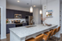 Modern kitchen with sleek granite countertops, dark cabinetry, stainless steel appliances, and elegant pendant lighting, perfect for entertaining.