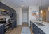 Modern kitchen with sleek dark cabinets, stainless steel appliances, and elegant pendant lighting over a spacious granite island.