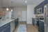 Contemporary kitchen with sleek navy cabinets, stainless steel appliances, and elegant pendant lighting over a granite countertop island.