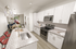 Elegant open-concept kitchen and dining area with sleek granite countertops, modern stainless steel appliances, and chic pendant lighting.